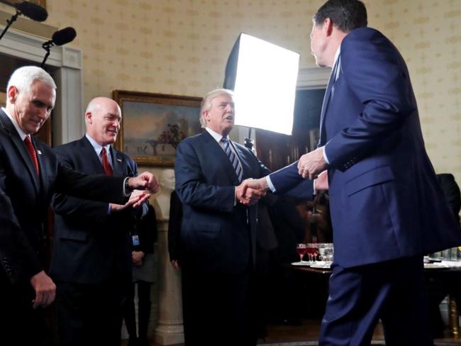 President Donald Trump shakes hands with FBI Director James Comey during a reception for law enforcement officers in the Blue Room of the White House on January 22. Picture: Alex Brandon.