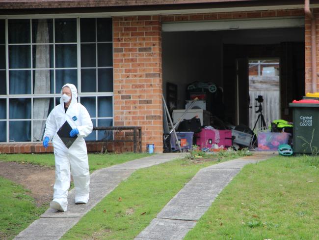 A police forensic team inside 13 Reeves St, Narara