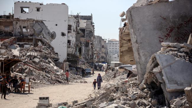 Palestinians walk near rubble and destroyed buildings amid the Israel-Hamas conflict in Khan Younis, in the southern Gaza Strip.