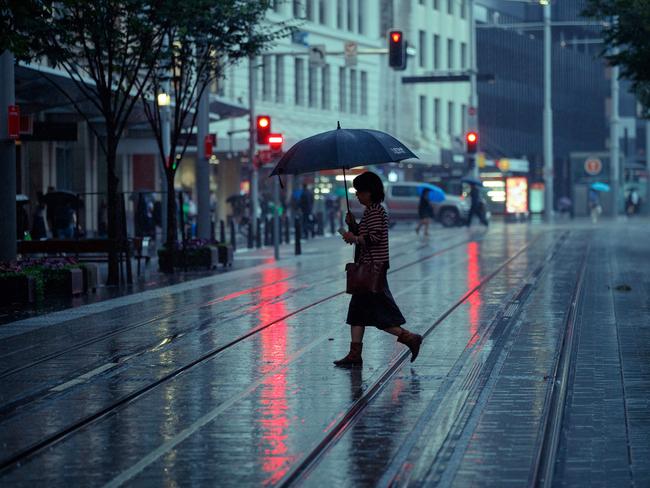 DAILY TELEGRAPH. Sydneysiders woke to drenching rain this morning. Picture shows commuters caught in the rain on George Street in the CBD this morning. 15/01/2024. Picture by Max Mason-Hubers