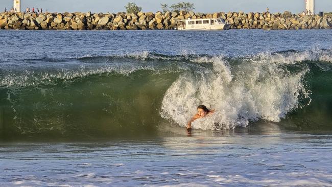 A body surfer enjoys a ride through a wave at Mooloolaba on Tuesday afternoon. Photo: Mark Furler