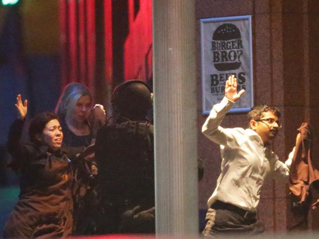 Making a run for it ... Freed hostages run from the cafe after the siege. Pic: Bill Hearne