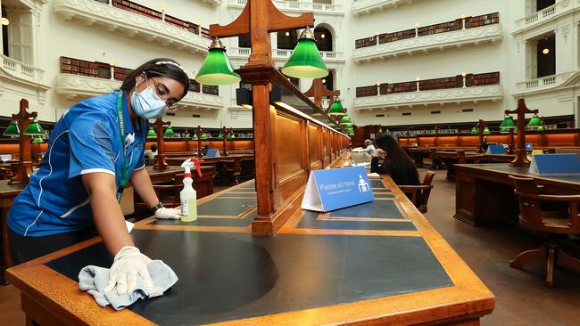 Cleaners Leiddy Duarte and Nixon Hortua clean and sanitise the State Library. Picture: Ian Currie