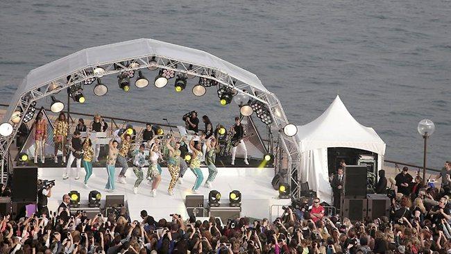 A ferry passes by as Katy Perry performs for Seven's breakfast program Sunrise outside the Opera House. Picture: AP