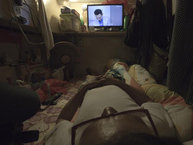 Simon Wong, an unemployed man, watches TV. Picture: Kin Cheung/AP