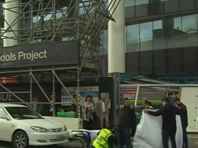 Paramedics help two women who were seriously injured after a construction-site fence fell on them on Tuesday afternoon. Pic: Channel 9