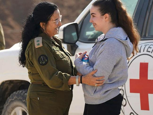 This handout picture released by the Israeli army shows freed Israeli hostage Agam Berger (R) being welcome by an Israeli soldier near a vehicle from the International Red Cross, after her release by Hamas in the Gaza Strip, on January 30, 2025, in Israel. Palestinian militant group Hamas handed over Israeli woman soldier Agam Berger January 30, as the third hostage-prisoner exchange of the Gaza ceasefire got under way. (Photo by Israel Army / AFP) / === RESTRICTED TO EDITORIAL USE - MANDATORY CREDIT "AFP PHOTO / HO / Israeli Army" - NO MARKETING NO ADVERTISING CAMPAIGNS - DISTRIBUTED AS A SERVICE TO CLIENTS ===