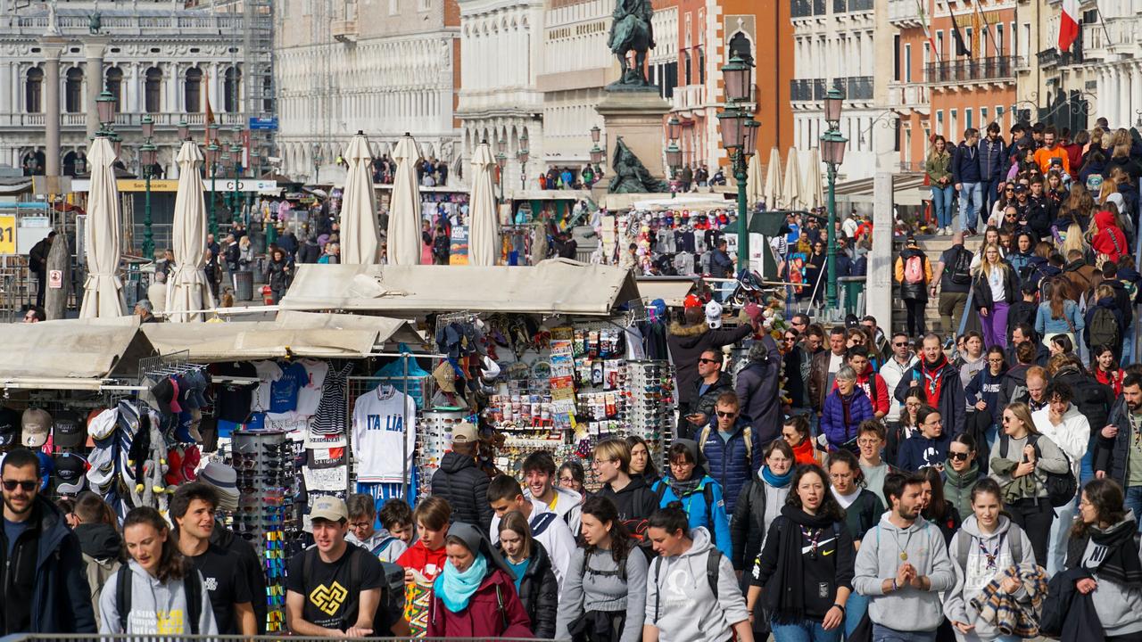 Tourists pass souvenir stalls in San Marco, the tourist heart of Venice. Picture: Andrea Merola/Bloomberg via Getty Images