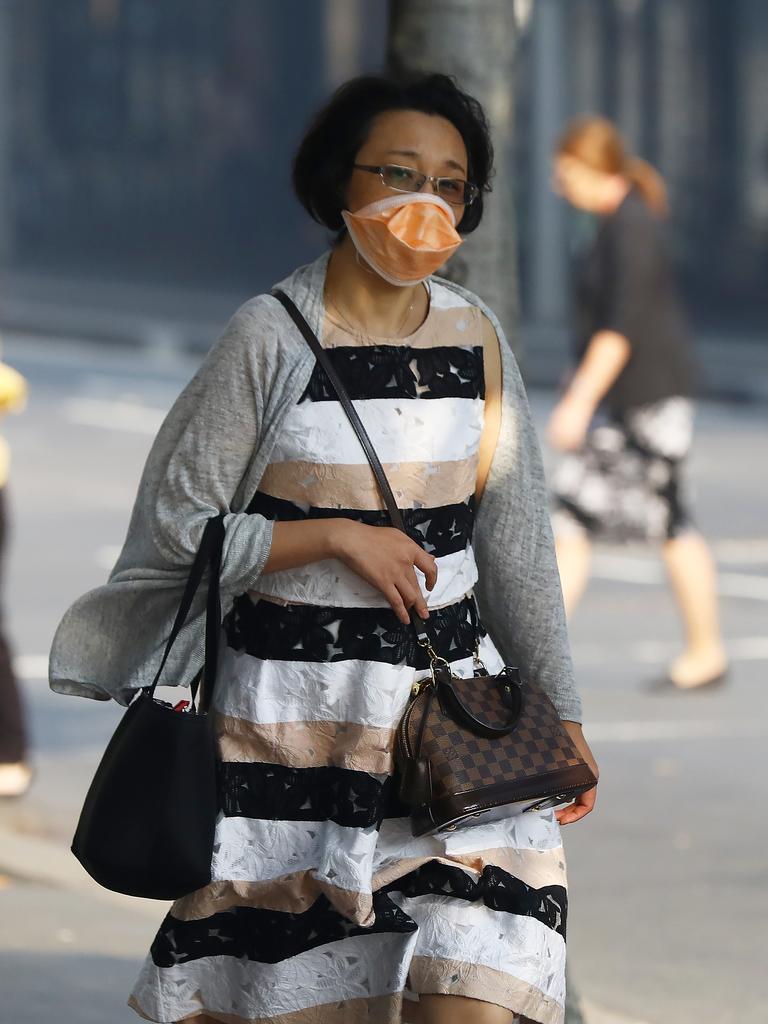 As smoke from bushfires engulfs Sydney, morning commuters are pictured wearing face masks as they make their way to work. Picture: MATRIX