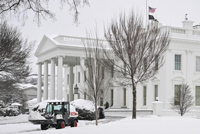 Workers remove snow outside the White House in Washington