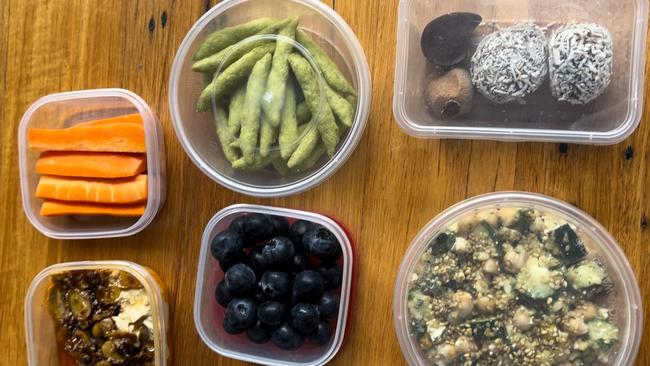 I made us a lunch to take on the flight, with snow pea chips, carrot sticks with hummus and chilli crisp, protein balls, blueberries and a bulgar wheat salad with cucumber, herbs, chickpeas, feta and pistachios. Picture: Simone Mitchell