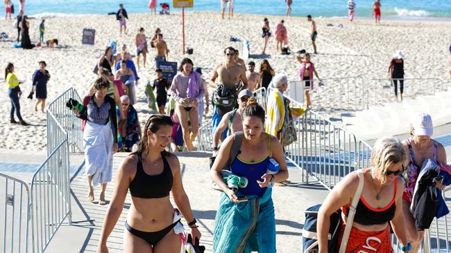 Beach-goers leave Coogee Beach after its closure today. Picture: Gaye Gerard