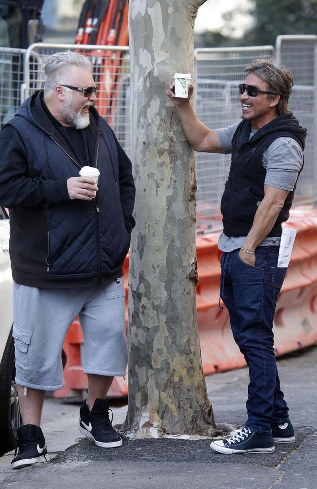 John Ibrahim shares a laugh with mate Kyle Sandilands who was refused entry at the former nightclub owner’s home as police executed a raid on Tuesday. Picture: MATRIX