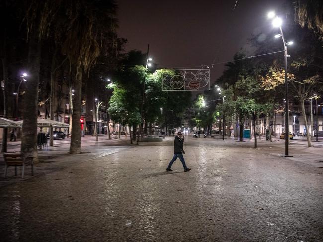 A pedestrian walks in the empty central street of La Rambla, as Spain's Catalonia reimposes a night-time curfew, closes nightclubs and limits social gatherings. Picture: AFP