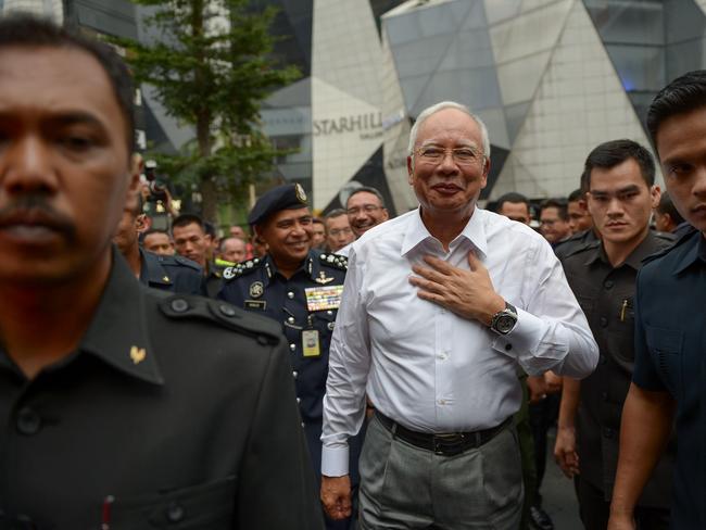 (FILES) This file photo taken on February 22, 2016 shows Malaysia's Prime Minister Najib Razak (C) arriving for a joint police-army exercise at a shopping mall in Kuala Lumpur. Malaysia's prime minister and the company he founded, 1MDB, have weathered a year-long barrage of corruption allegations with nothing-to-see-here assurances, but a string of recent revelations is placing those denials under growing strain. / AFP PHOTO / MOHD RASFAN