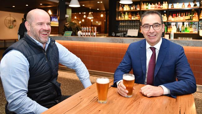 South Australian Premier Steven Marshall (right) and Adelaide Crows football director and Alma Tavern owner Mark Ricciuto enjoy a beer at the pub on Monday to celebrate the easing of COVID-19 restrictions. Picture: AAP Image/David Mariuz