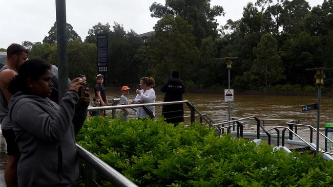 What’s a bit of water? The overflowing weir always attracts attention. Picture: Bianca De Marchi