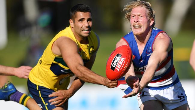 Travis Schiller evades Jared Petrenko to get his handball away. Picture: Mark Brake/AAP