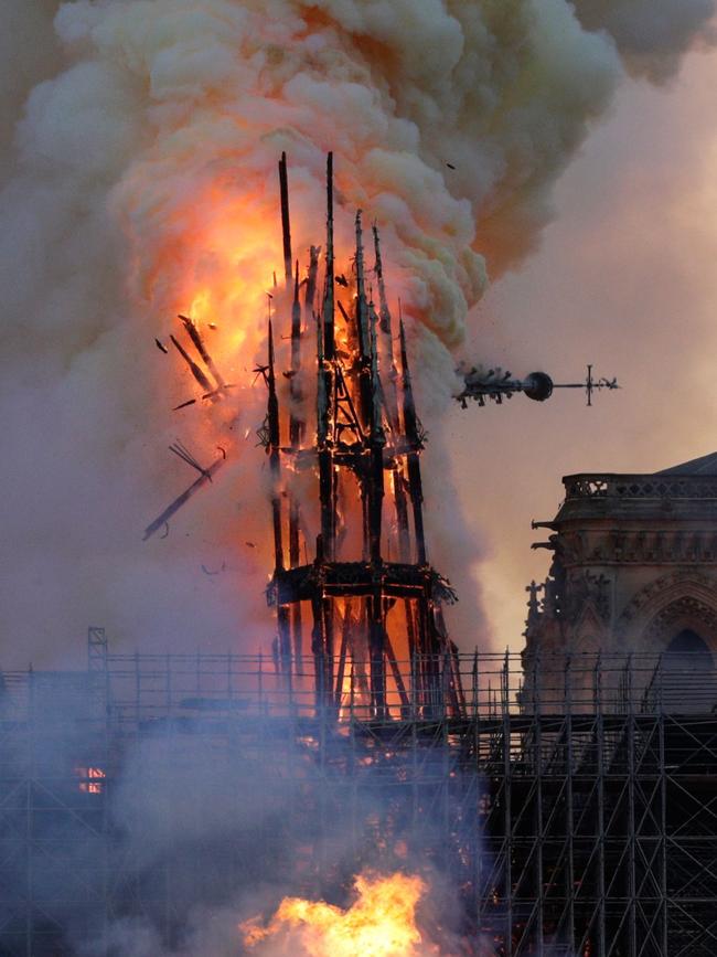 The steeple collapses as smoke and flames engulf the Notre-Dame Cathedral in Paris on April 15, 2019. - A huge fire swept through the roof of the famed Notre-Dame Cathedral in central Paris on April 15, 2019, sending flames and huge clouds of grey smoke billowing into the sky. The flames and smoke plumed from the spire and roof of the gothic cathedral, visited by millions of people a year. A spokesman for the cathedral told AFP that the wooden structure supporting the roof was being gutted by the blaze. (Photo by Geoffroy VAN DER HASSELT / AFP)
