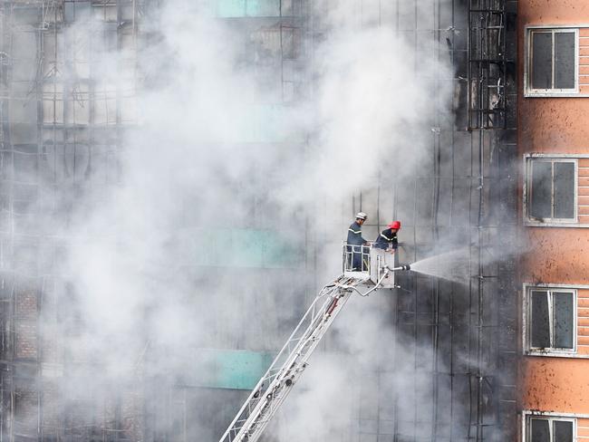 Firefighters extinguish the deadly blaze at a karaoke bar in Hanoi. Picture: AFP