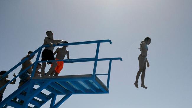 Children jump from a diving platform at a swimming pool near the town of Shtime, Kosovo, during a heatwave. July 2023 will probably be the world's hottest month in "hundreds, if not thousands, of years," a top NASA climatologist said on July 21.