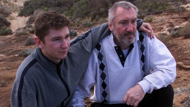 Vadim Volkov (left) with his father Victor looking at wreckage of their fishing boat at Southend near Beachport in 2002.