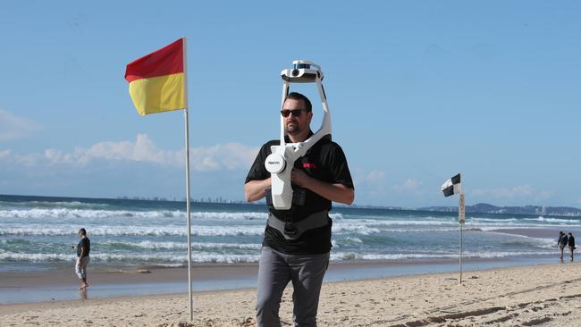 Gold coast Airshow boss Kevin Elliott looks like a Storm Trooper walking around Surfers beachfront wearing a Navis LiDAR 3D Scanner to map to Surfers Paradise Foreshore. Picture Glenn Hampson