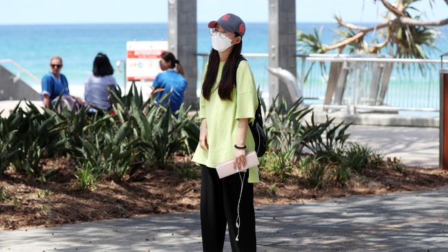 A woman wears a mask at Surfers Paradise, on the Gold Coast. Picture: NIGEL HALLETT