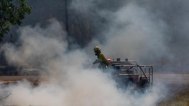 A firefighter can be seen putting out a spot fire on Bridgemary Cres, Girraween. Picture: Che Chorley