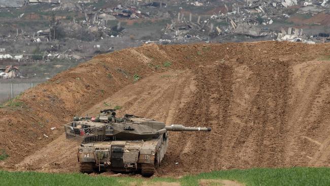 This picture taken from the Israeli side of the border with the Gaza Strip shows an Israeli army tank stationed on a hill overlooking northern Gaza on February 12, 2025, amid a truce in the war between Israel and Hamas. Mediators Qatar and Egypt were pushing to resolve a crisis in the Gaza ceasefire, a Palestinian source told AFP, after Israel and the United States told Hamas to release hostages this weekend or face a return to war. (Photo by Menahem KAHANA / AFP)