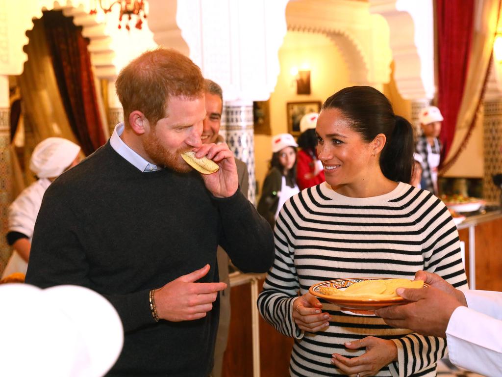 The royal pair tuck into local cuisine at a cooking demonstration. Picture: Getty 