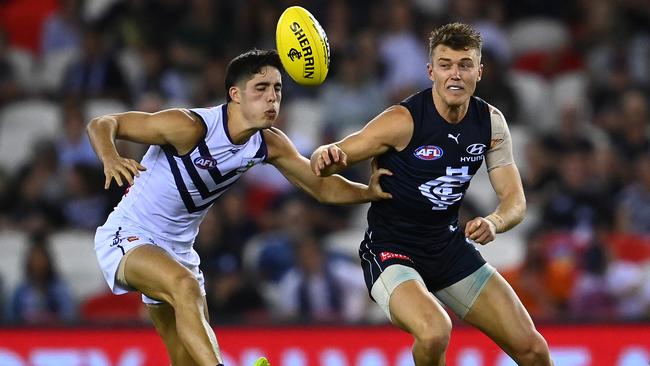 MELBOURNE, AUSTRALIA – APRIL 04: Patrick Cripps of the Blues handballs while being tackled by Adam Cerra of the Dockers during the round 3 AFL match between the Carlton Blues and the Fremantle Dockers at Marvel Stadium on April 04, 2021 in Melbourne, Australia. (Photo by Quinn Rooney/Getty Images)