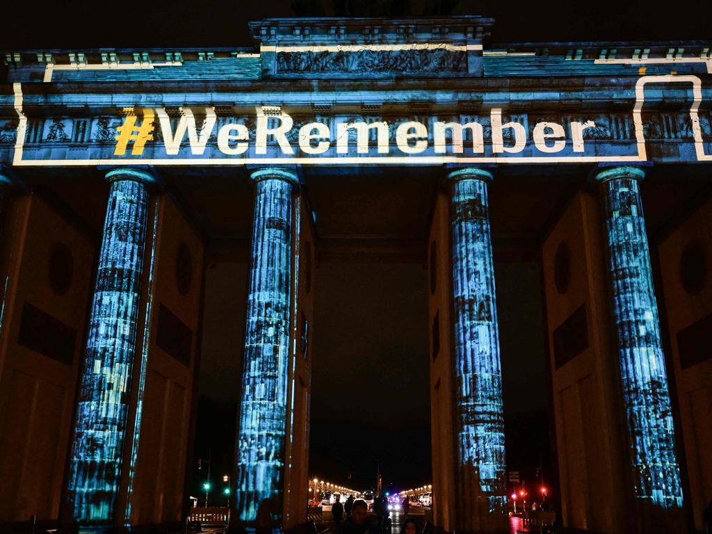 TOPSHOT - Berlin's landmark Brandenburg Gate is illuminated with the inscription "WeRemember" on January 27, 2025 in Berlin, as part of the remembrance ceremonies for the 80th anniversary of the liberation of the German Nazi concentration and extermination camp Auschwitz-Birkenau by the Red Army, in Oswiecim, Poland. (Photo by John MACDOUGALL / AFP)