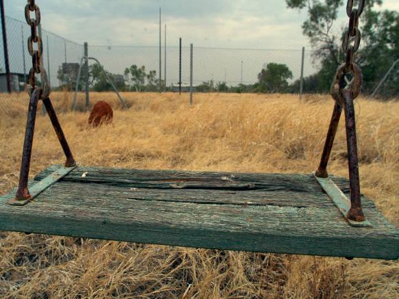 NewsAust19-12-2004 Overgrown play area at the back of Social Club. Colin Baker sole teacher at Warrego Primary School. Colin llives with his wife (Admin) at Warrego. (50km west of Tennant Creek, N.T.). A ghost town closed down in 1998 after the copper prices bottomed out. At its peak 5000 people lived at Warrego Mine