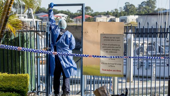 A police forensic officer taking photographs of fingerprints at the security gate after the fire. Picture: Jerad Williams