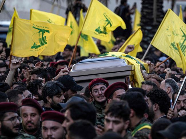 Hezbollah fighters carry the casket of slain commander Fuad Shukr. Picture: AFP