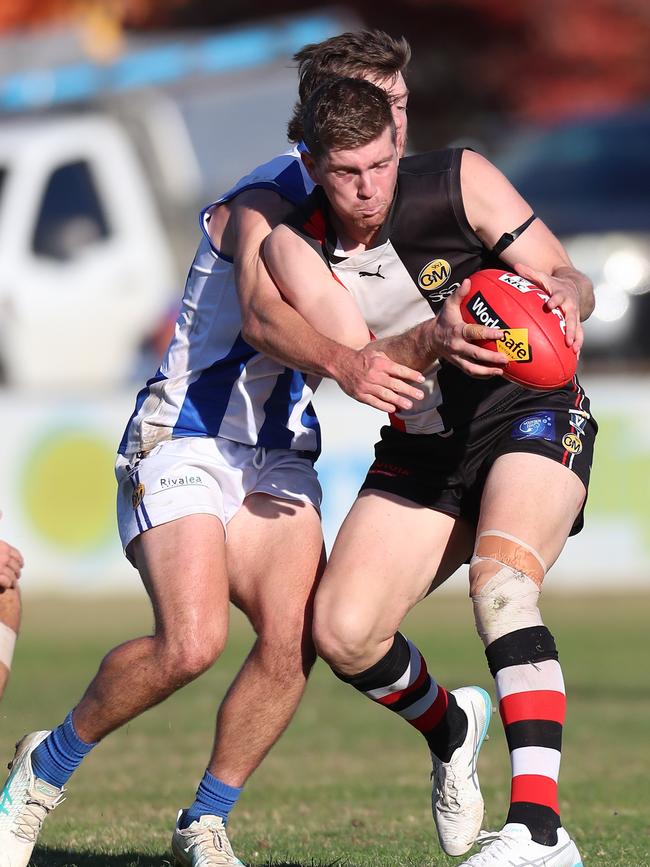 Myrtleford’s Ryley Sharp gathers the ball in front of Corowa-Rutherglen’s Jack Rowston.