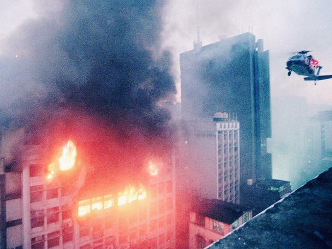 A helicopter hovers above a building engulfed in flames in Hong Kong in 1996. Picture: AP