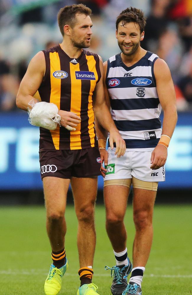 MELBOURNE, AUSTRALIA - MARCH 28: Luke Hodge of the Hawks, talking to Jimmy Bartel of the Cats, walks off after defeat with ice strapped to his arm during the round one AFL match between the Geelong Cats and the Hawthorn Hawks at Melbourne Cricket Ground on March 28, 2016 in Melbourne, Australia. (Photo by Michael Dodge/Getty Images)