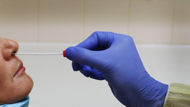 Registered Nurse Laxman Adhikari conducts a nasal swab test in the clinical assessment room at St George Hospital in Sydney.