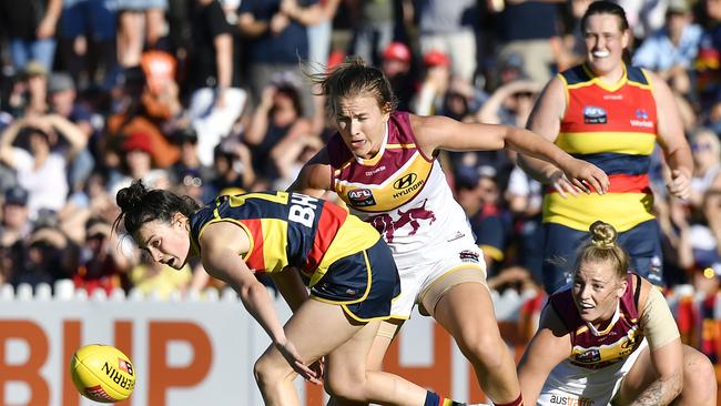 Eloise Jones of the Crows, left, fights off Brisbane opponents during the Round 1 AFLW match at Norwood Oval. Picture: AAP Image/Roy Vandervegt