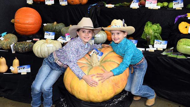 Isla Martin (9) and her sister Lacey Martin (6) and the grand champion pumpkin at the show. Heritage Bank Toowoomba Royal Show.