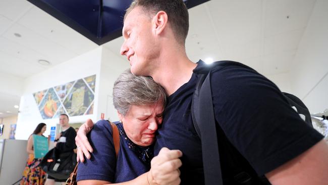 An emotional Avril Irons hugs her son Travis Irons for the first time in nine months after he arrived on the first flight from Sydney. Picture: Scott Powick / News Corp