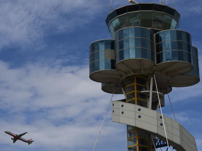 The control tower at Sydney Airport is seen as a plane takes off in Sydney, Friday, March 29, 2019. Flights are slowly resuming after Sydney Airport's air traffic control tower was evacuated after smoke was detected inside. (AAP Image/Peter Rae) NO ARCHIVING