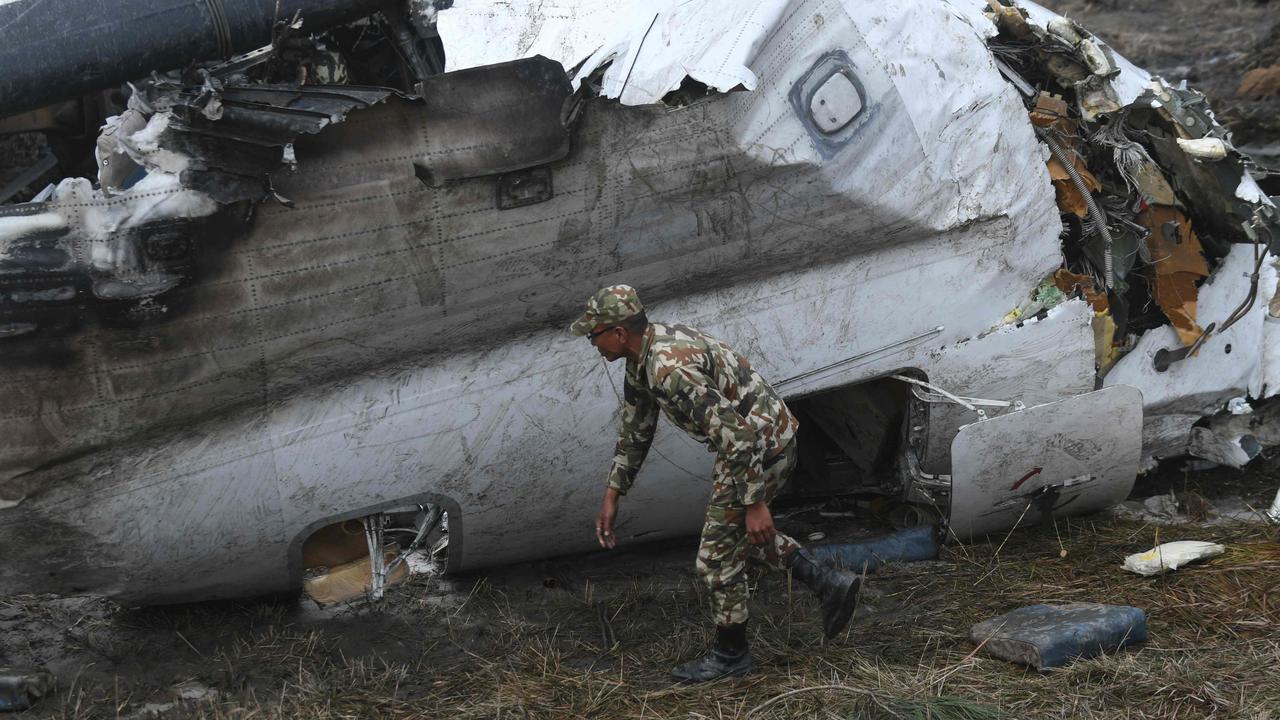 A Nepali rescue worker looks at wreckage of an US-Bangla Airlines plane that crashed near the international airport in Kathmandu on March 12, 2018. Picture: Prakash Mathema/AFP