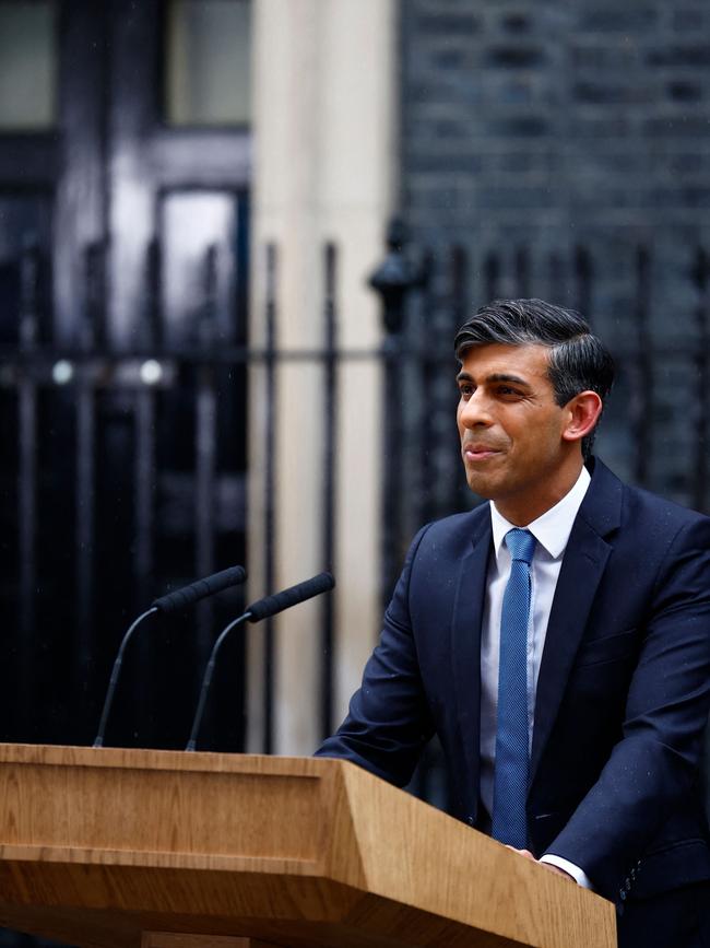 Britain's Prime Minister Rishi Sunak, soaked in rain, stands at a lecturn as he delivers a speech to announce July 4 as the date of the UK's next general election. Picture: AFP