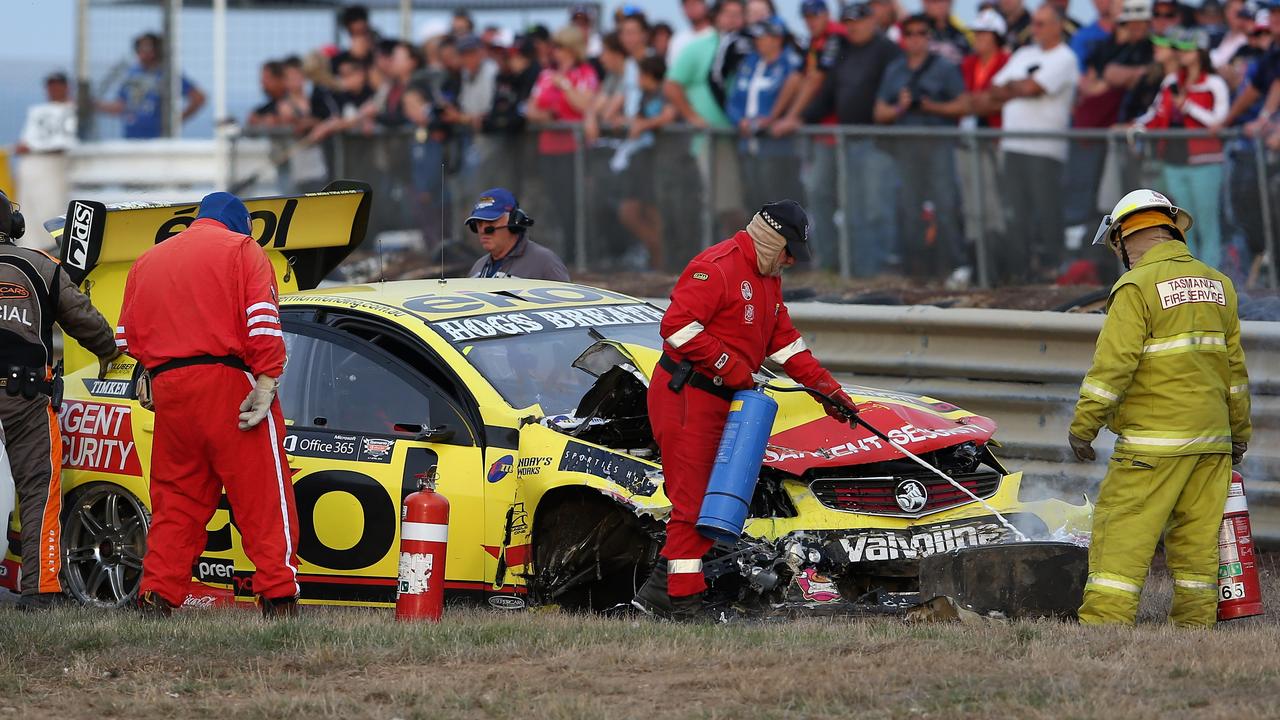 Marshals inspect the wrecked car of Scott Pye at Symmons Plains in 2013.
