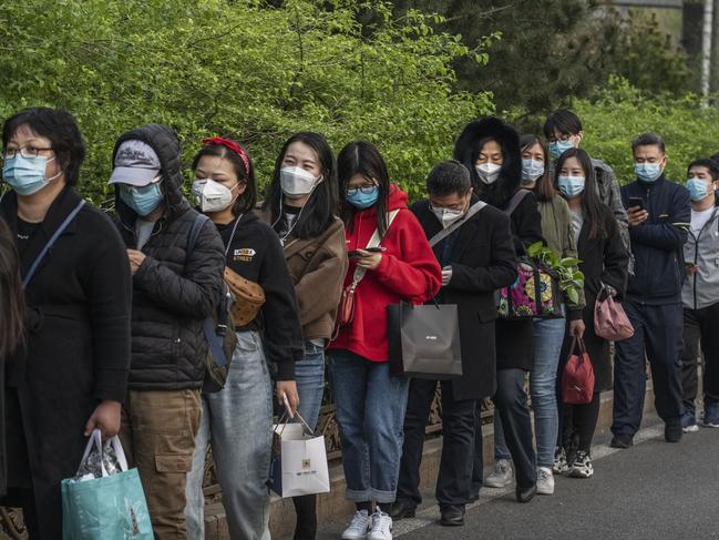 BEIJING, CHINA - APRIL 07: Chinese commuters wear protective masks as they line-up and wait to board a public bus home in the central business district during rush hour on April 7, 2020 in Beijing, China. China recorded for the first time since January 21st no coronavirus-related deaths. With the pandemic hitting hard across the world, officially the number of coronavirus cases in China is dwindling, ever since the government imposed sweeping measures to keep the disease from spreading.  For more than two months, millions of people across China have been restricted in how they move from their homes, while other cities have been locked down in ways that appeared severe at the time but are now being replicated in other countries trying to contain the virus. Officials believe the worst appears to be over in China, though there are concerns of another wave of infections as the government attempts to reboot the worlds second largest economy. In Beijing, it is mandatory to wear masks outdoors, some retail stores still operate on reduced hours, restaurants employ social distancing among patrons, and tourist attractions at risk of drawing large crowds remain closed or allow only limited access.  Monitoring and enforcement of virus-related measures and the quarantine of anyone arriving to Beijing is carried out by neighborhood committees and a network of Communist Party volunteers who wear red arm bands. Since January, China has recorded more than 81,000 cases of COVID-19 and at least 3200 deaths, mostly in and around the city of Wuhan, in central Hubei province, where the outbreak first started. (Photo by Kevin Frayer/Getty Images)