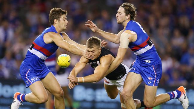 Josh Dunkley and Marcus Bontempelli tackle Carlton’s Patrick Cripps. Picture: Michael Klein.