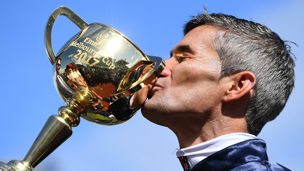 Corey Brown kisses the Melbourne Cup after Rekindling won the 2017 Melbourne Cup.